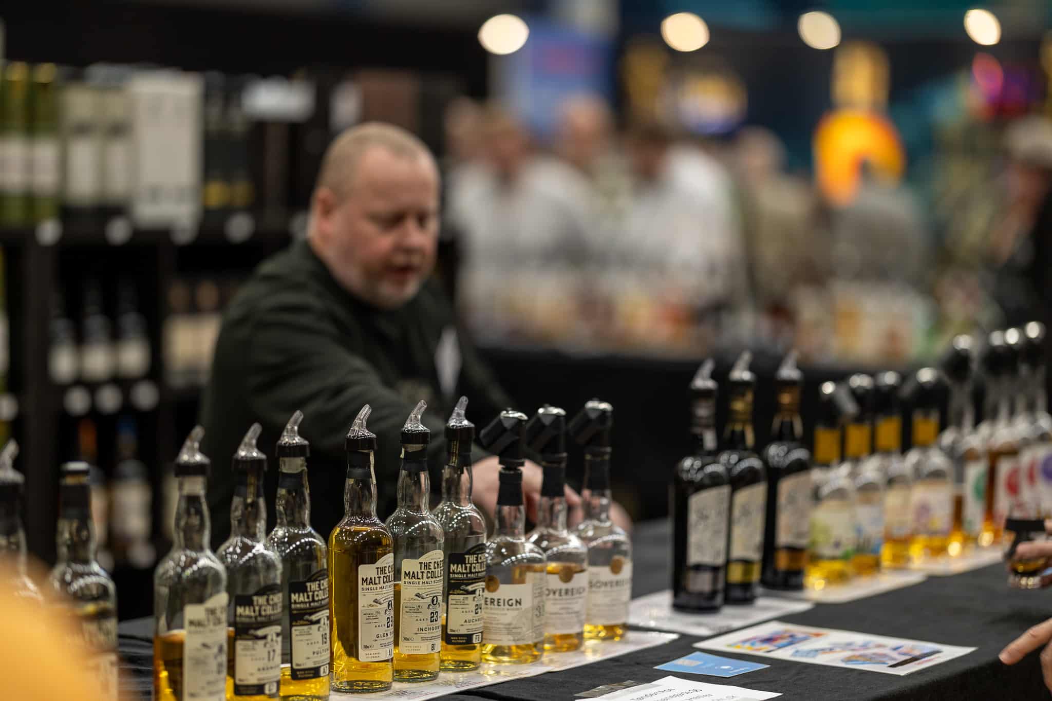 Mand står foran en række af whiskeyflasker